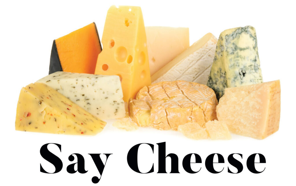 Assortment of cheese wedges above the words “Say Cheese”.