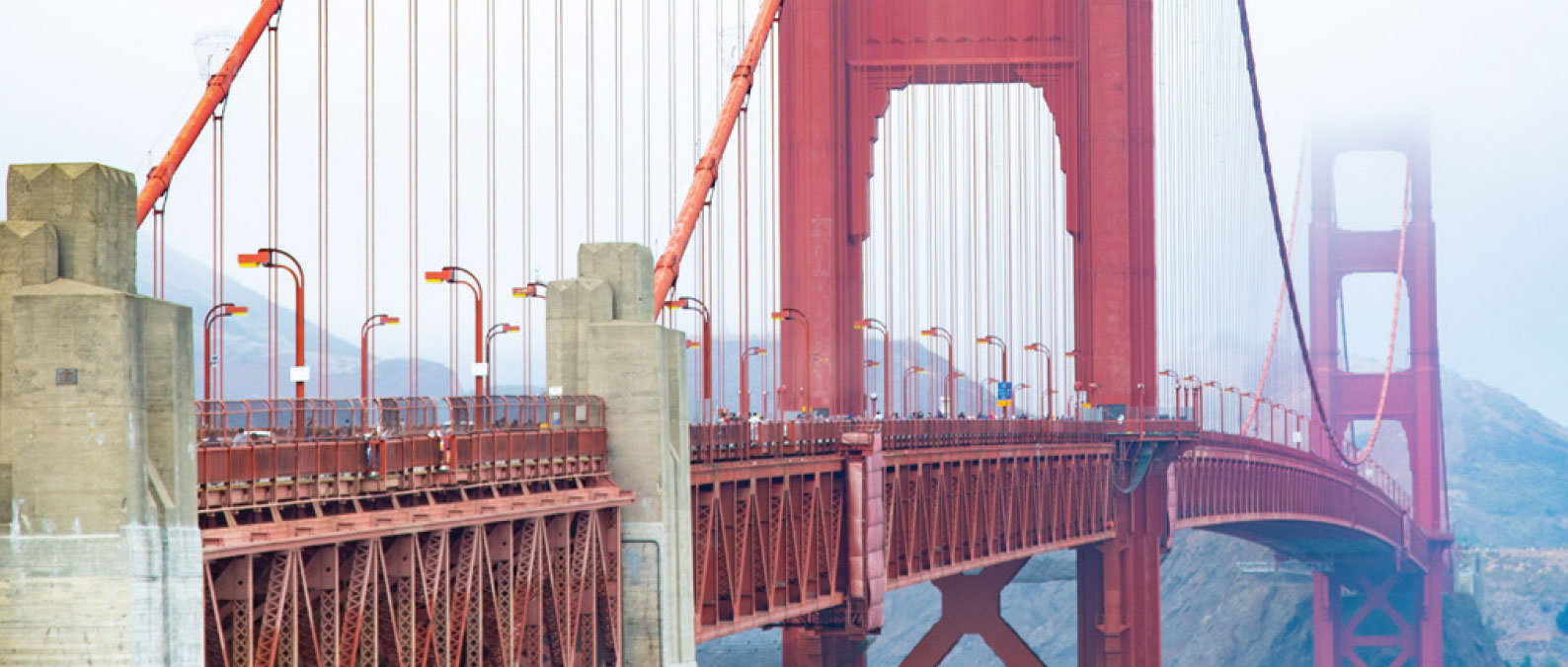 View along the Golden Gate Bridge with its red towers and suspension cables.