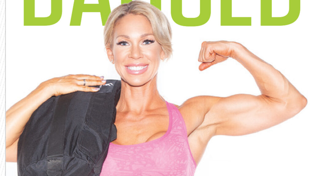 Smiling woman resting a black sandbag on one shoulder while flexing her other arm beneath cropped headline text.