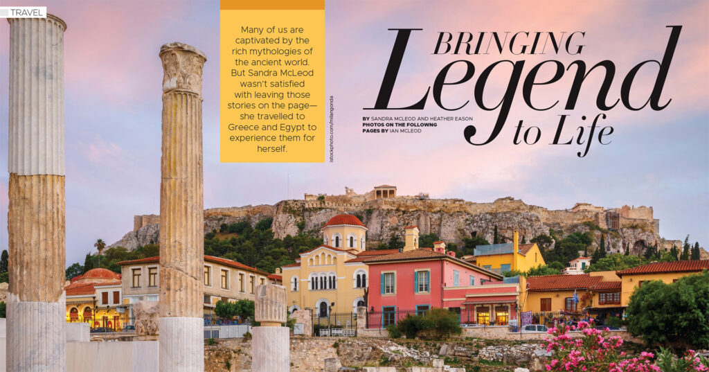 Ancient Greek columns in the foreground with colorful buildings and the Acropolis hill in Athens under a pink sky at sunset.