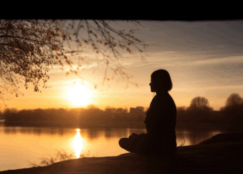 woman meditating at sunset