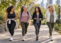 Diverse group of women over 40 walking together on a leafy park path