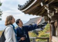 Woman learning about Kyoto temple architecture with a local guide.